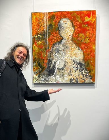 Lachender Erik Groesch zeigt mit vielen Händen auf das warme, rot geprägte Face Off Bild von Sergio Gomez